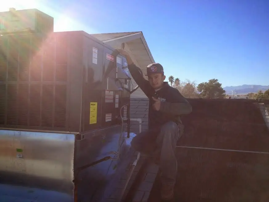 HVAC technician performing AC Tune-Up on a rooftop unit in Hanahan